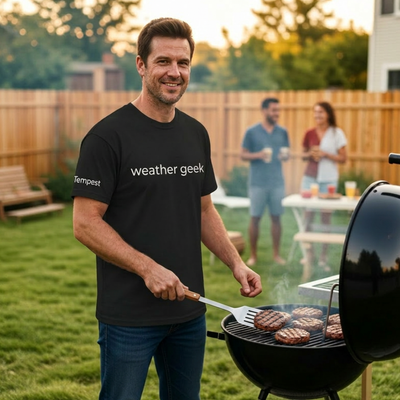 man grilling outdoors wearing a weather geek t-shirt